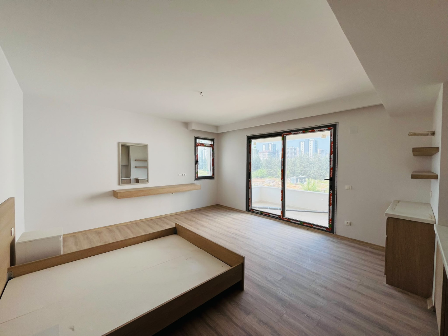 MB Azure Resort A Blok 1+0 stüdyo dairenin yaşam alanı ve balkon kapısı