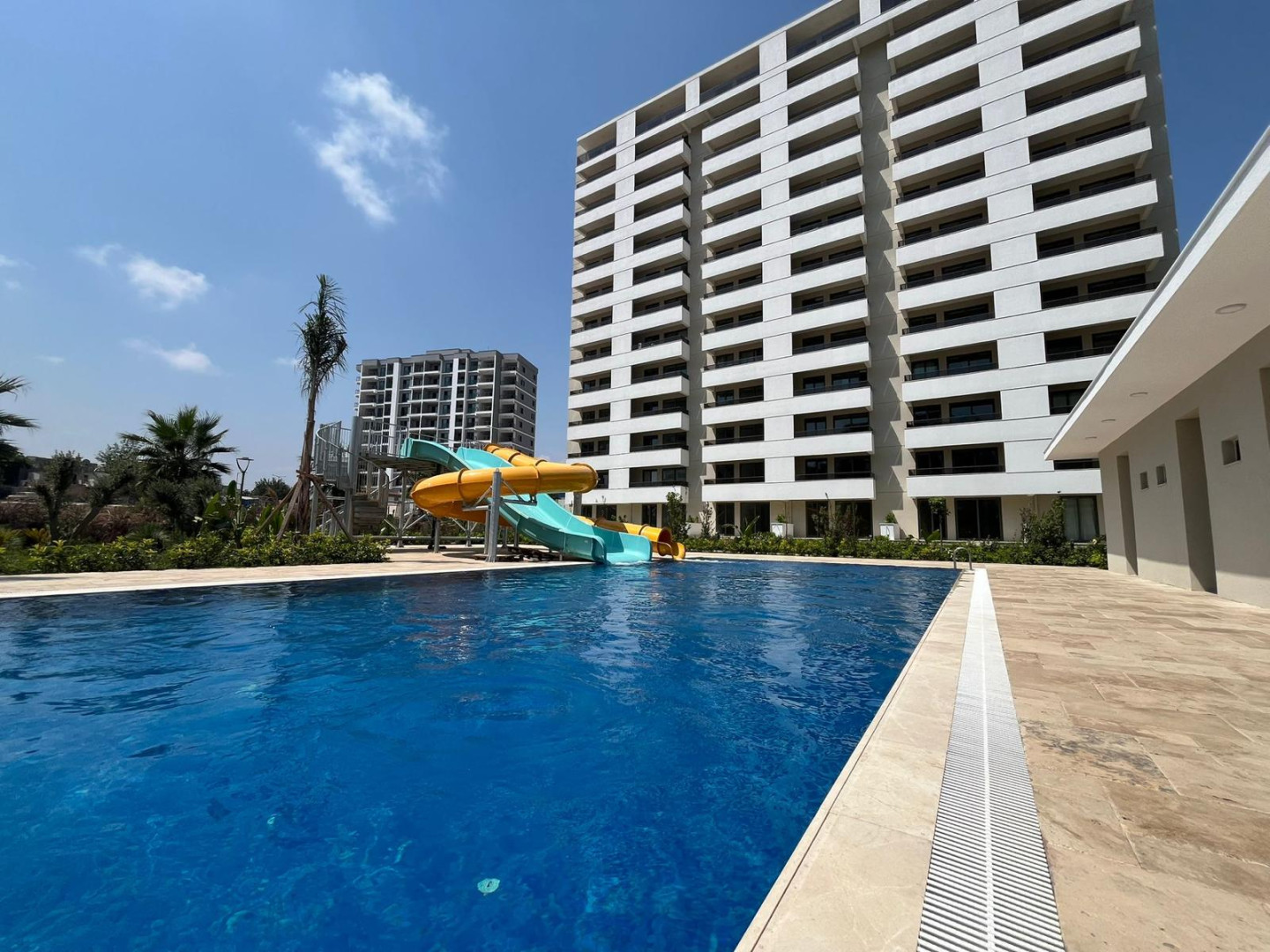 MB Nature Resort 1+1 Bahçe Katı – havuz, kaydırak ve blok dış cephesi